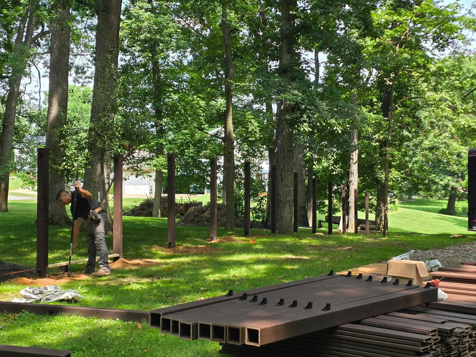 A crew member setting and leveling a composite fence post